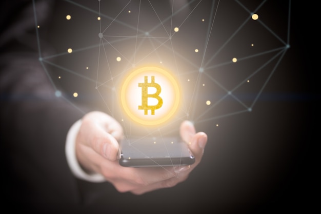 Empresário com smartphone com sinal de bitcoin