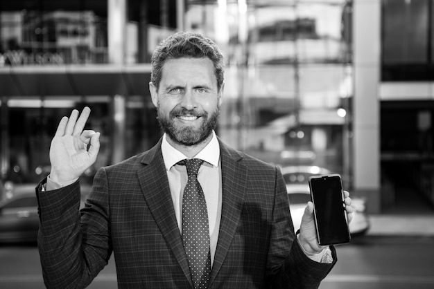 Empresário com telefone Retrato de trabalhador de escritório alegre falando no celular em pé perto...