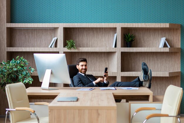 Empresário com terno elegante sentado na mesa do computador no escritório