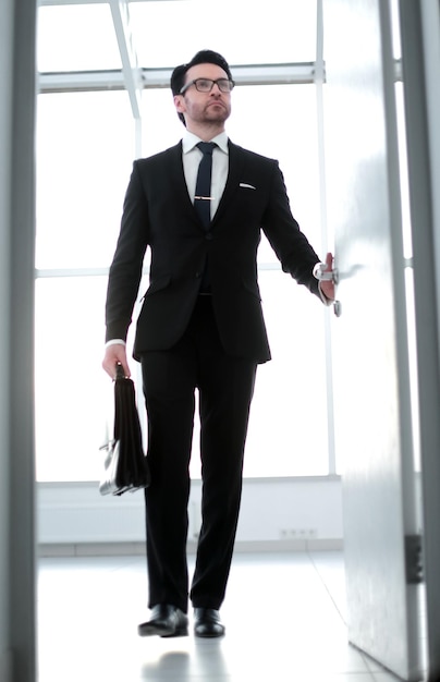 Foto empresário com uma maleta de couro entrando no conceito de negócios do escritório de seu cliente