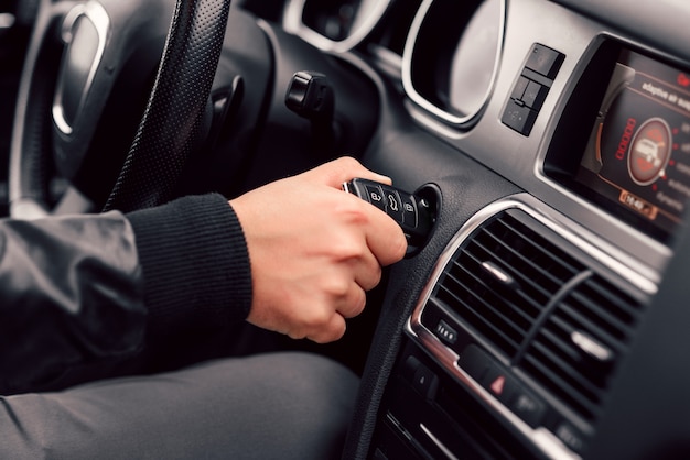 Empresário começa seu carro moderno e elegante com a chave