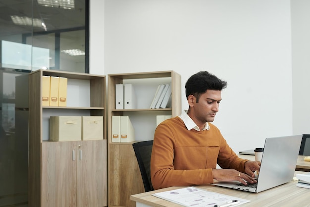 Empresario concentrado que trabaja en la computadora portátil