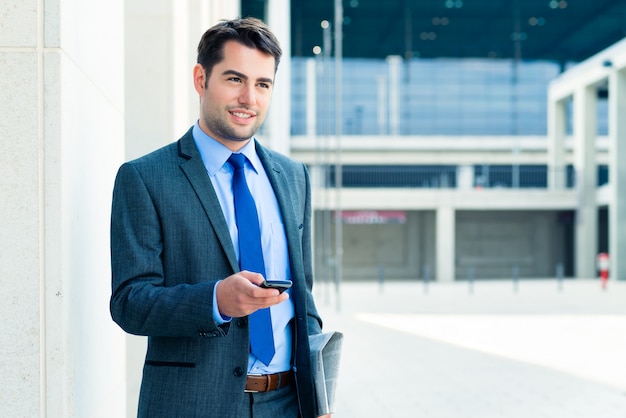 Empresário confiante ao ar livre usando telefone