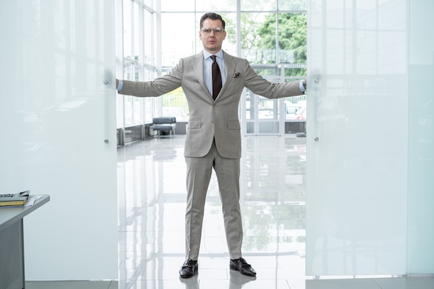 Foto empresário confiante bonito terno entrando no escritório.