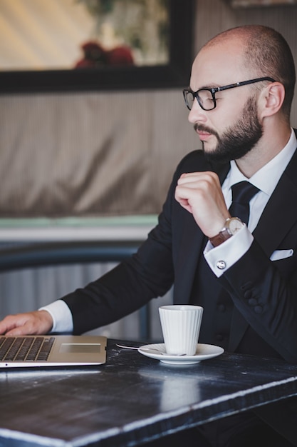 Empresário confiante em copos, sentado em um café na pausa para o café.