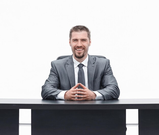 Foto empresário confiante sentado atrás de uma mesa isolada em branco