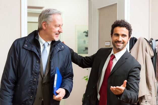 Empresário, congratulando-se com outro empresário em seu escritório