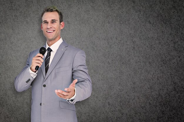 Foto empresário dando discurso contra fundo cinza