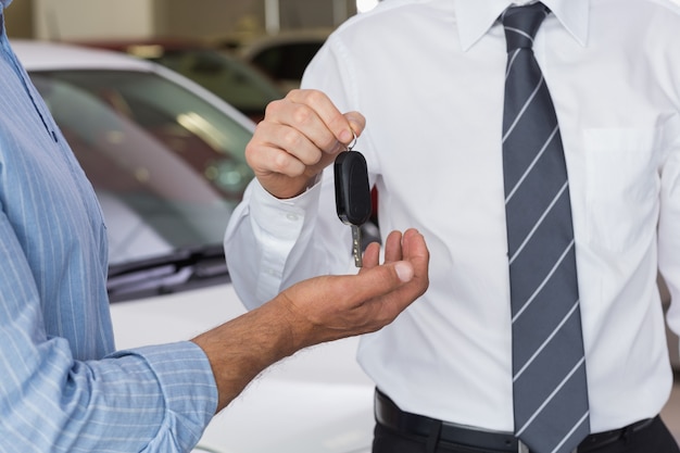 Empresario dando la llave del coche al cliente