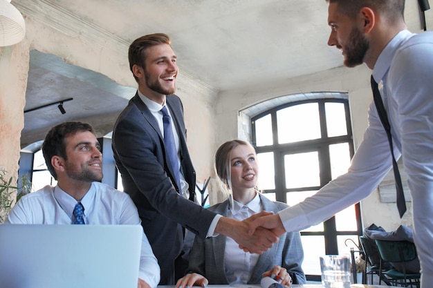 Empresario dándose la mano para sellar un trato con su socio y colegas en el cargo