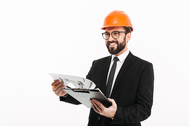 Foto empresário de engenheiro no capacete segurando documentos.