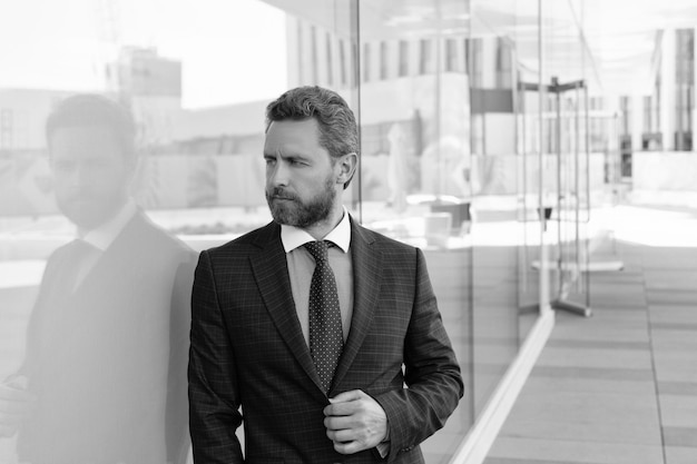 Empresário de homem barbudo maduro em traje formal empresarial fora do traje formal do escritório