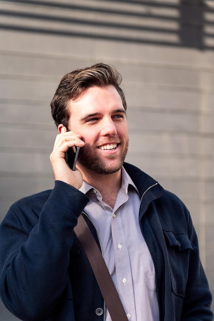 Empresário de homem sorridente falando por telefone