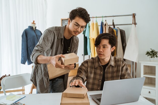 Empresário de jovens asiáticos conversando sobre o produto da embalagem