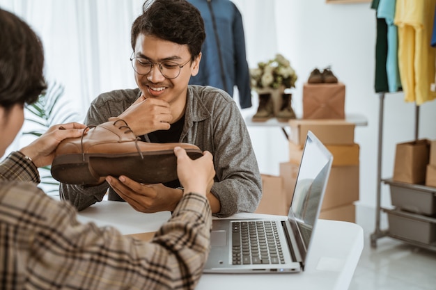 Empresário de jovens asiáticos conversando sobre o produto de sapatos