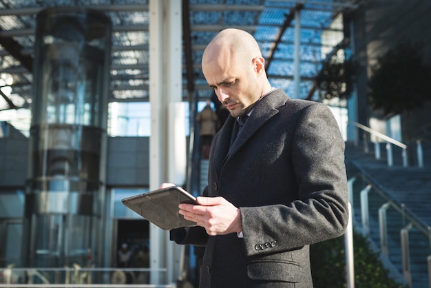 empresário de moda elegante bem sucedido usando tablet