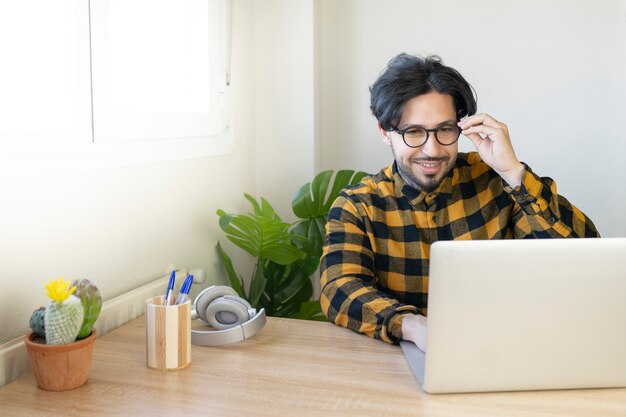 Empresário de óculos sentado em um escritório usando um computador