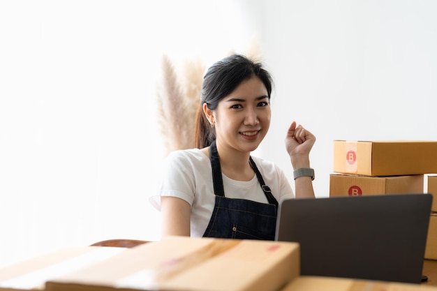 Empresário de retrato sorrindo e se sentindo feliz enquanto prepara pacotes para enviar aos clientes Jovem mulher com muitos pedidos on-line