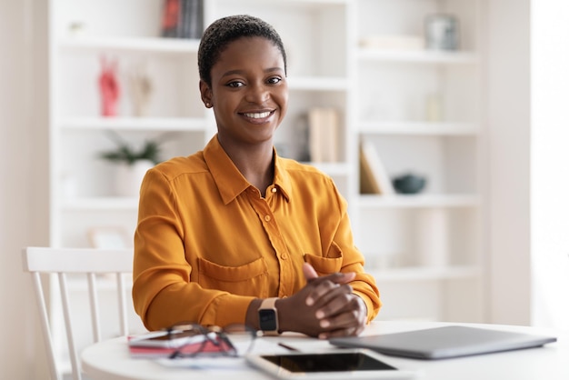 Empresário de senhora negra alegre sentado na mesa de trabalho