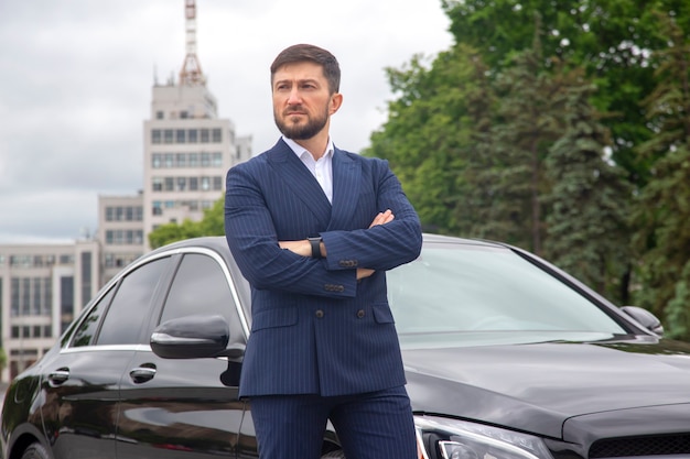 Empresário de sucesso perto de seu carro de prestígio