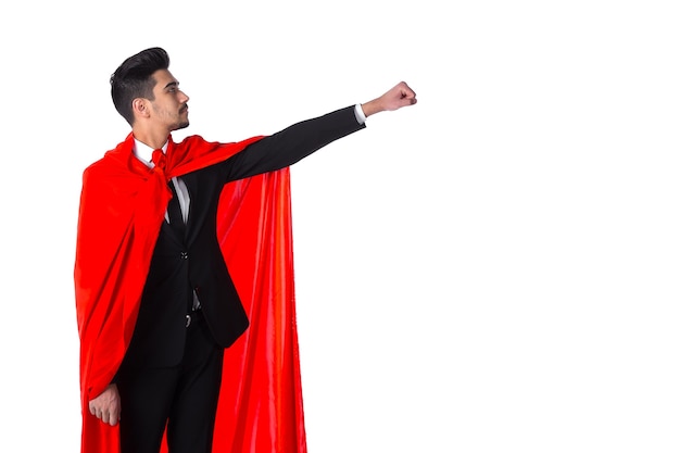 Empresário de terno e capa vermelha de super-herói levanta a mão, fundo branco. jovem gerente de escritório como um super-homem. copyspace