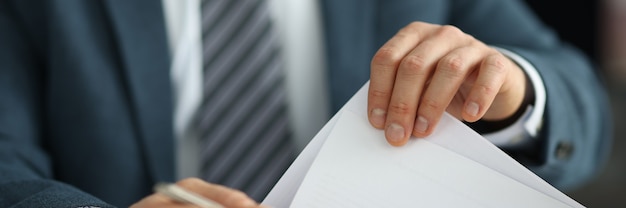 Empresário de terno segurando documentos nas mãos em close-up do escritório conceito de gestão de RH