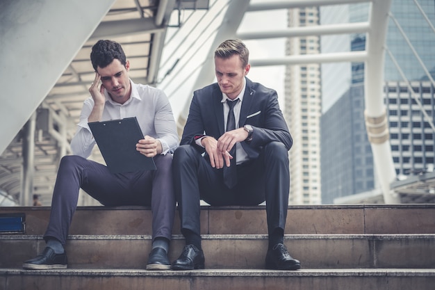 Empresario deprimido y cansado sentado en la ciudad