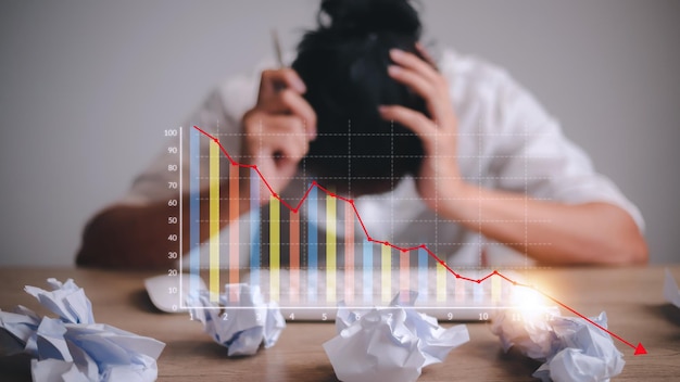 Foto empresário deprimido inclinando a cabeça sob um gráfico ruim do mercado de ações