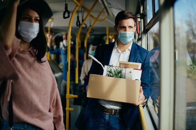 Empresario despedido que viajaba a casa en autobús y usaba mascarilla debido a la pandemia del coronavirus