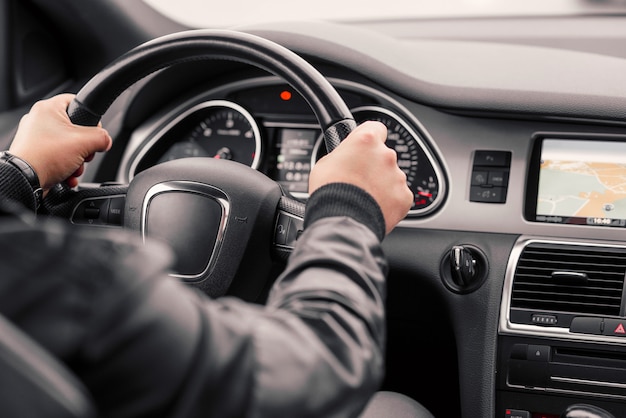 Empresário, dirigindo o carro moderno de luxo na cidade.