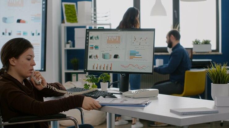 Foto empresario discapacitado ocupado hablando por teléfono con un colega comprobando gráficos