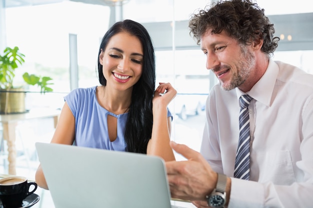 Empresario discutiendo con un colega sobre laptop