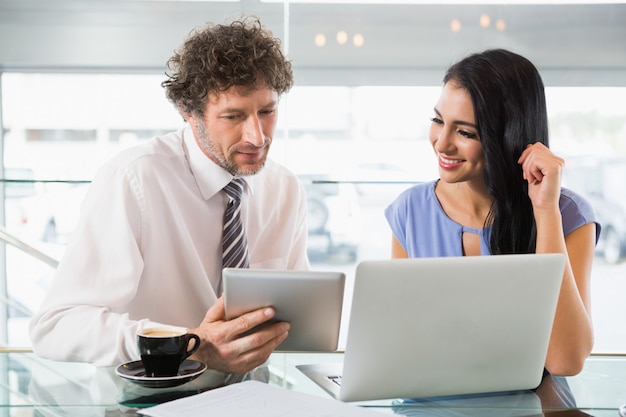 Empresario discutiendo con un colega sobre tableta digital