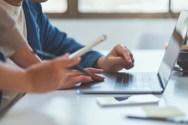 Empresário discutindo e trabalhando em um laptop no escritório