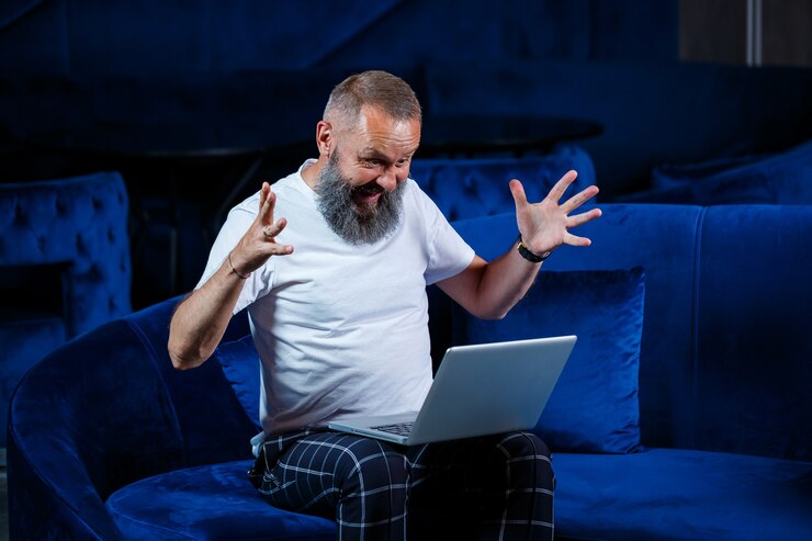 Empresário do sexo masculino se senta com uma xícara de café e faz um novo projeto com caretas no rosto.