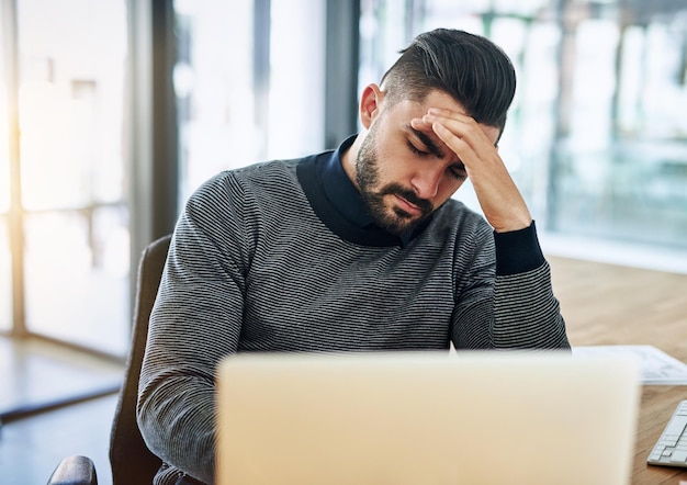 Empresário dor de cabeça e estresse com laptop no escritório para burnout trabalho chato e sobrecarregado de trabalho por espaço de trabalho empregado profissional e enxaqueca do trabalho prazo com dor fadiga e frustrado