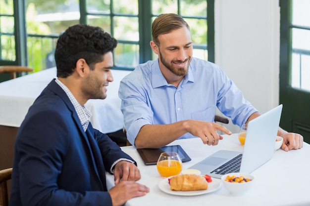 Empresário e colega usando laptop