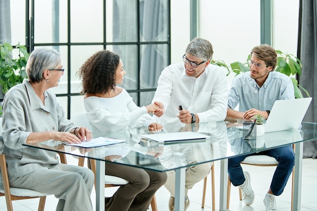 Empresário e empresária apertando as mãos durante uma reunião