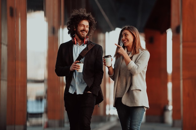 Foto empresário e empresária conversando e segurando bagagem viajando em viagem de negócios, carregando café fresco nas mãos. conceito de negócios. foto de alta qualidade