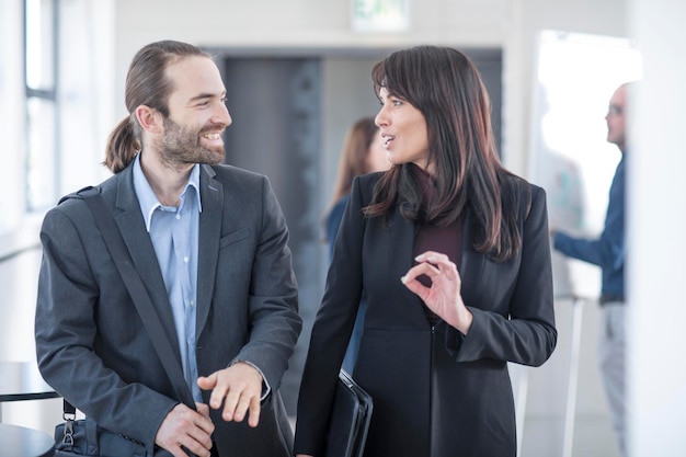 Empresário e empresária conversando no escritório