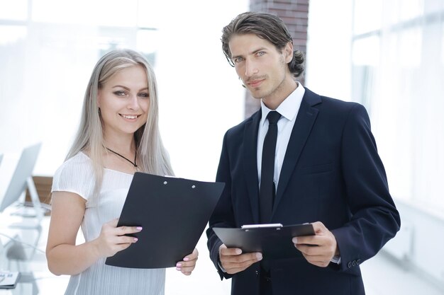 Empresário e empresária discutindo documentos antes da reunião