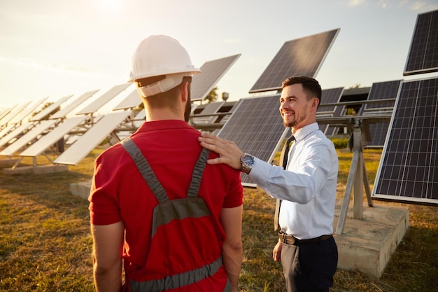 Empresário e engenheiro em campo com baterias solares