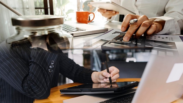 Empresário e equipe analisando demonstração financeira Tarefa de finanças com smartphone e laptop e tablet Conceito de gerenciamento de riqueza