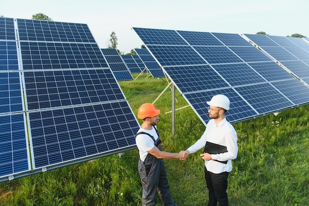 Empresário e trabalhador perto de baterias de energia solar Cliente comercial mostrando detalhes fotovoltaicos ao capataz Dois homens fazendo acordo