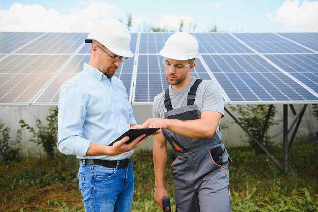 Empresário e trabalhador perto de baterias de energia solar dois homens fazendo negócio