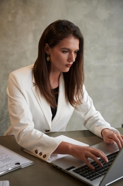 Empresario elegante que trabaja en la computadora portátil