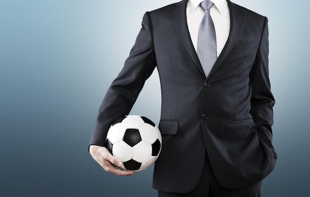 Empresário elegante segurando uma bola de futebol de perto