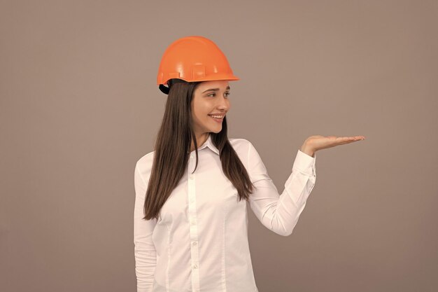 Foto empresário em negócios de segurança de capacete dia do trabalho mulher feliz trabalhadora apresentando produto