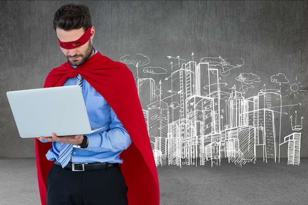 Foto empresário em traje de super-herói usando laptop