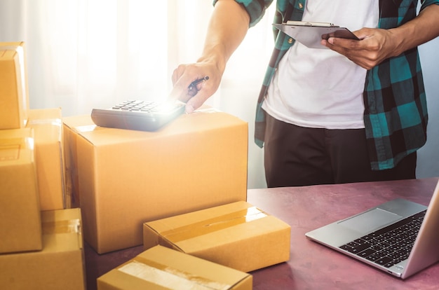 Foto empresário embalagem do produto em caixa de papelão entregar ao cliente trabalhando em home office